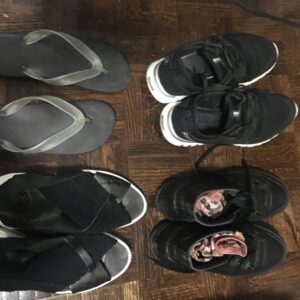Four pairs of shoes, clockwise from the top left: flip-flops, running shoes, hiking shoes, and sandals