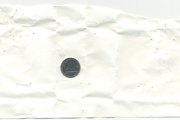 Unfolded notebook page from Step 2 with a dime inside