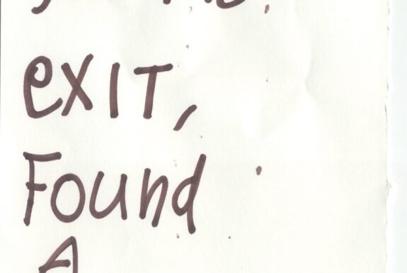 Notebook page from Step 2 with the words 'I looked for the exit, found a sleeve' in thick black marker